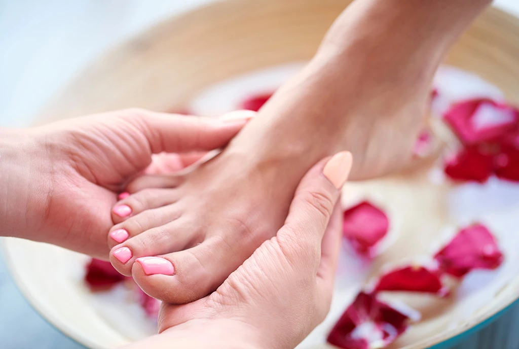 Soin de pédicure avec massage des pieds et pétales de rose dans un bol de spa – Euphoria Hair & Beauty Studio.